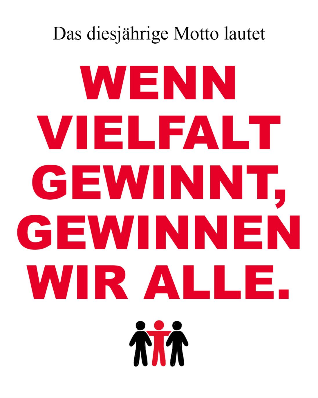 In roten Großbuchstaben auf weißem Hintergrund der Satz: "Das diesjährige Motto lautet: Wenn Vielfalt gewinnt, gewinnen wir alle."